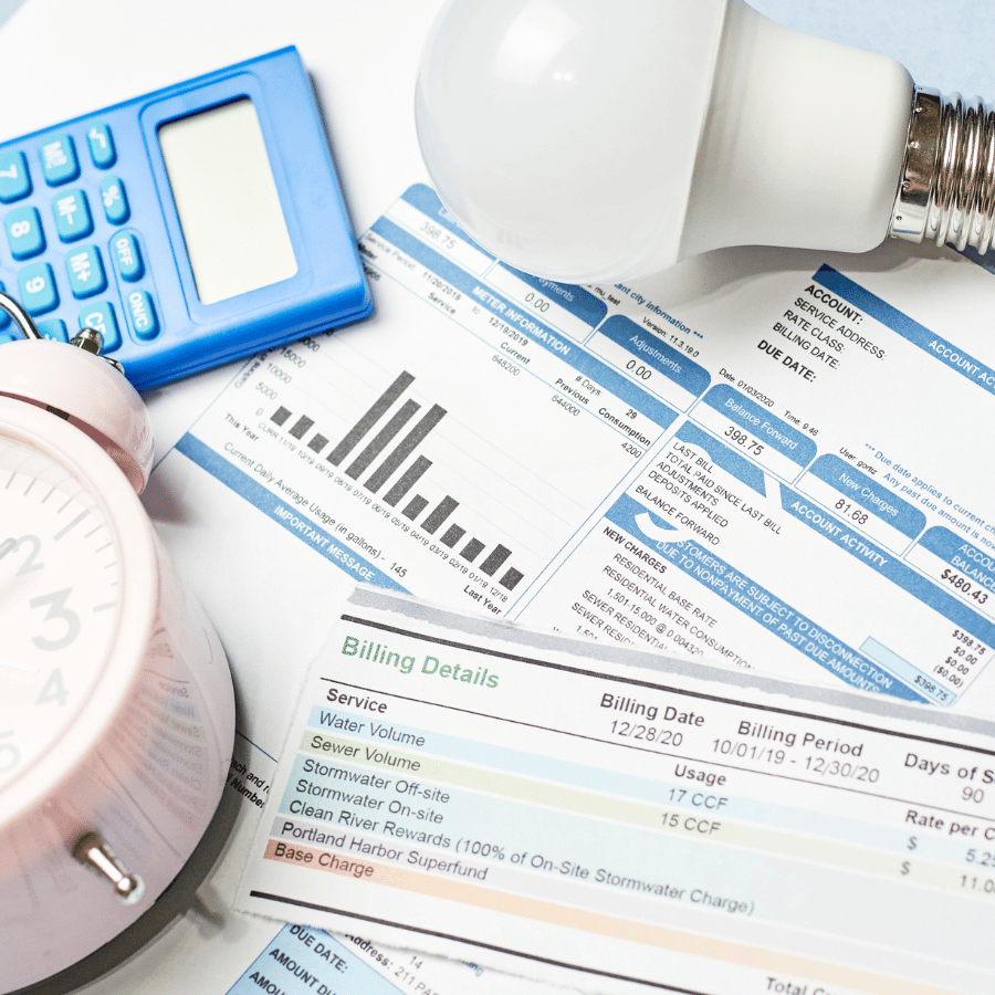 Calculator, bulb, magnifier, and charts on bills, suggesting finance or utility analysis