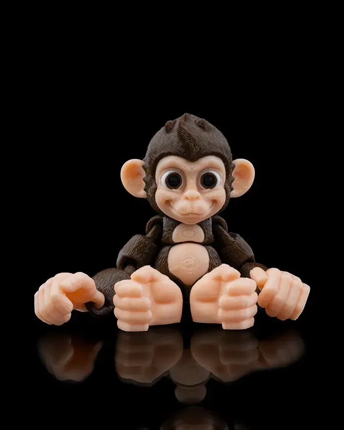A toy monkey is sitting on a black surface
