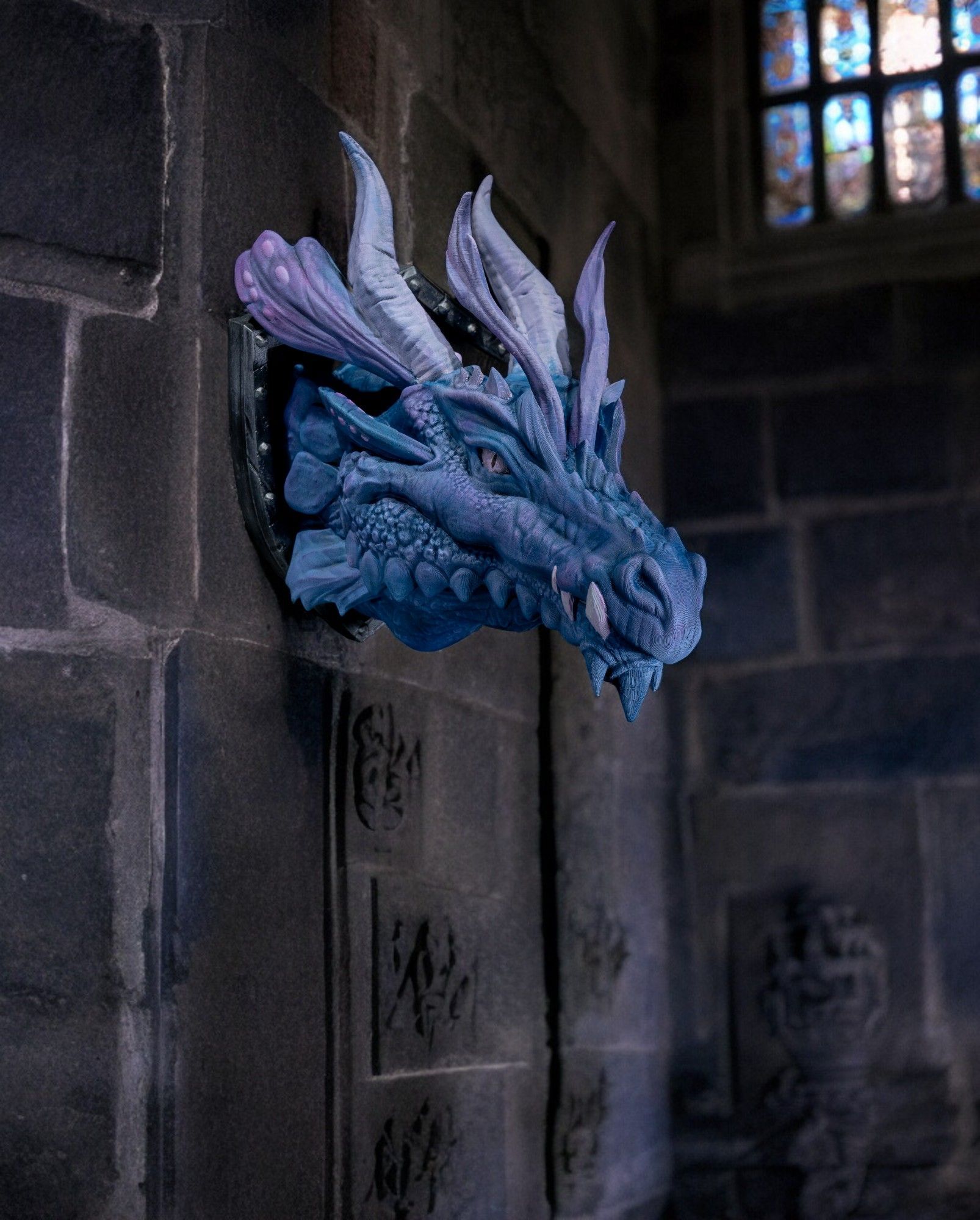 A blue and purple dragon head is hanging on a brick wall