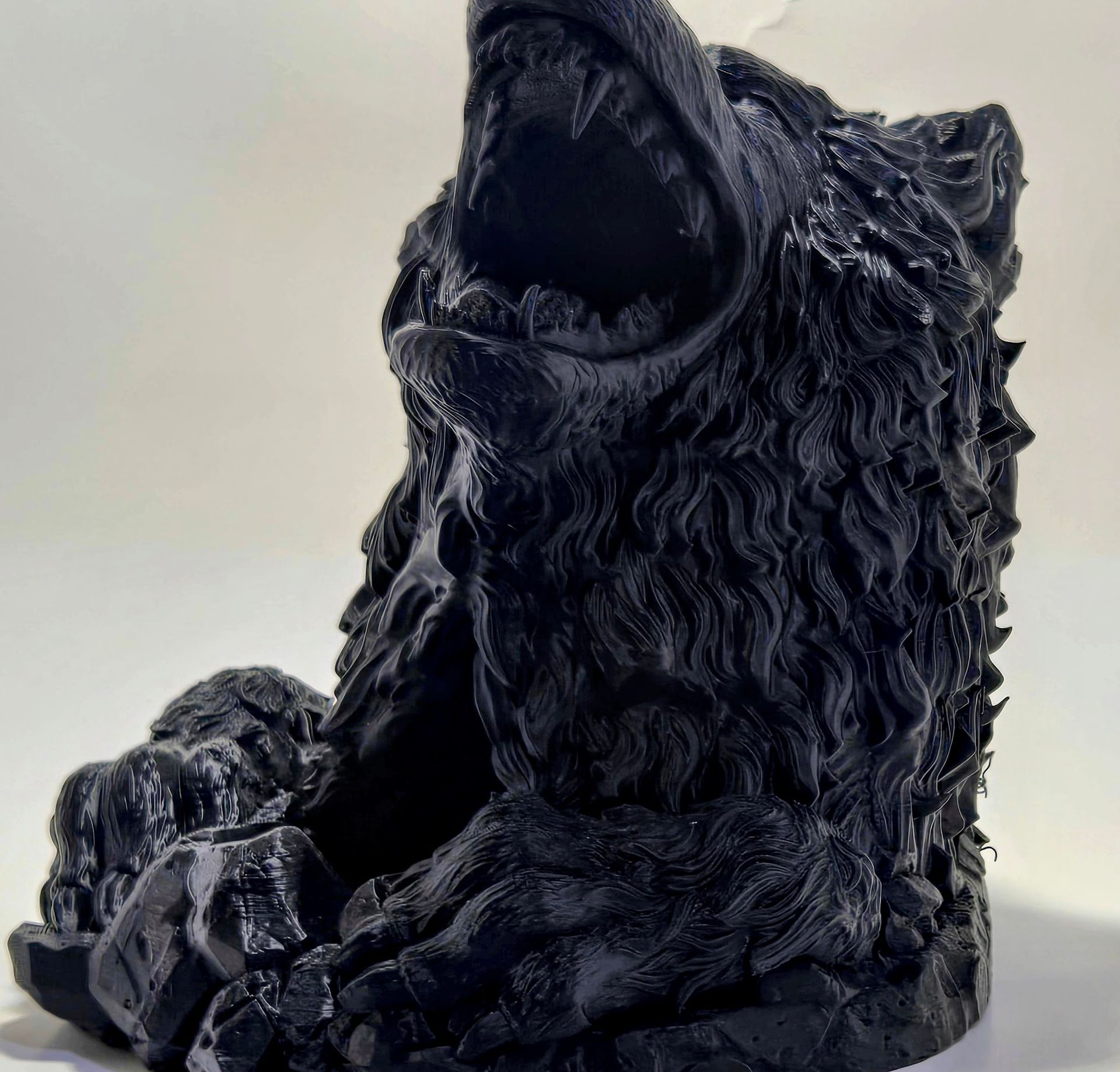 A black statue of a bear with its mouth open