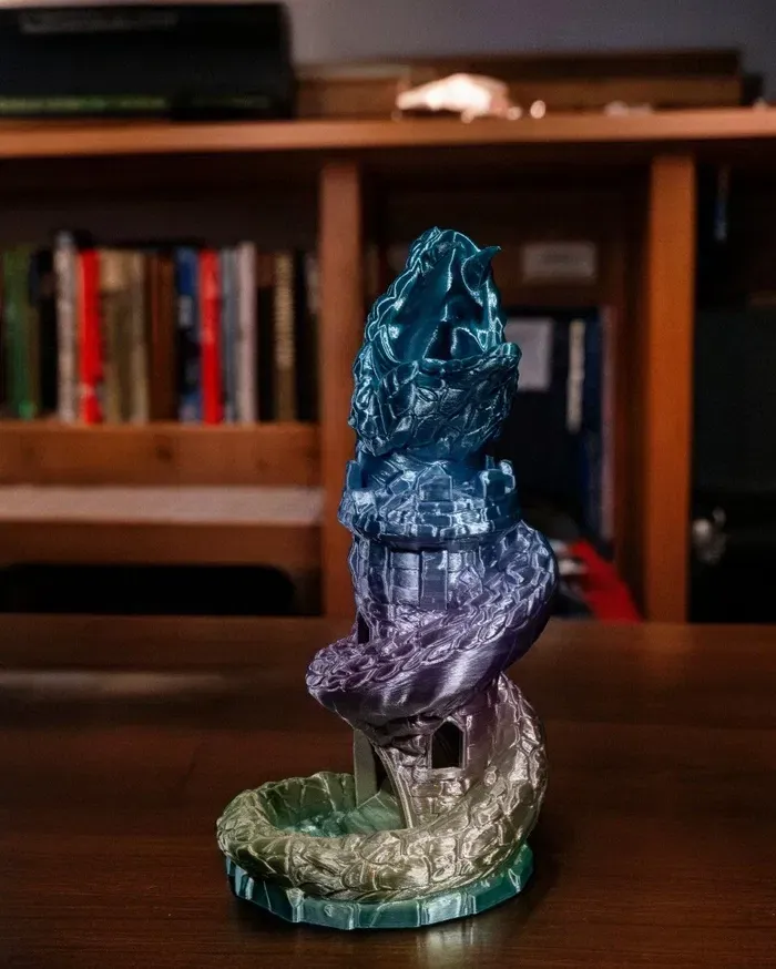 A statue is sitting on a wooden table in front of a bookshelf.