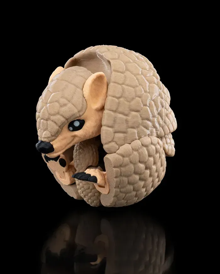 A close up of a toy armadillo on a black background.