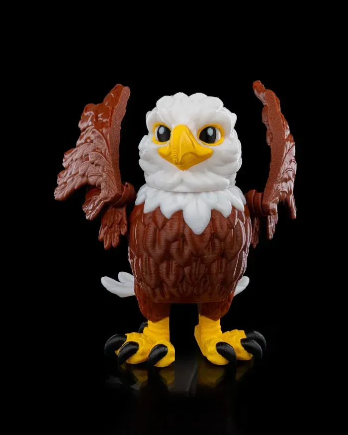 A toy bald eagle with its wings outstretched on a black background.