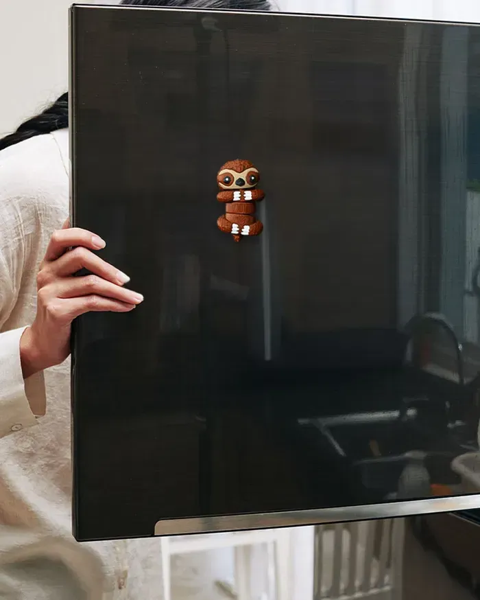 A person is holding a black box with a sticker on it.