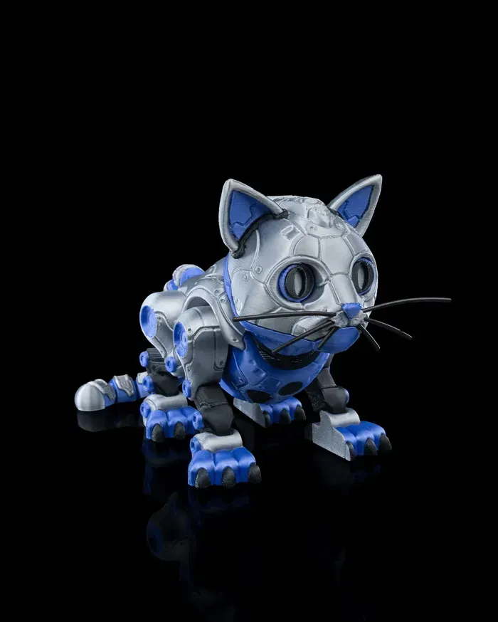 A robotic cat is sitting on a black surface.