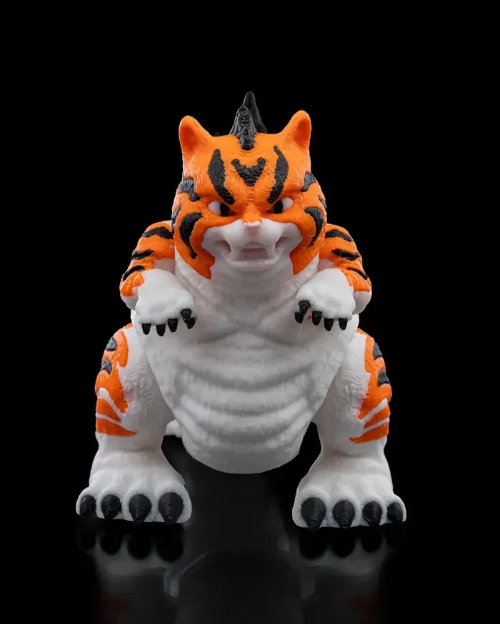 A toy tiger is sitting on a black surface