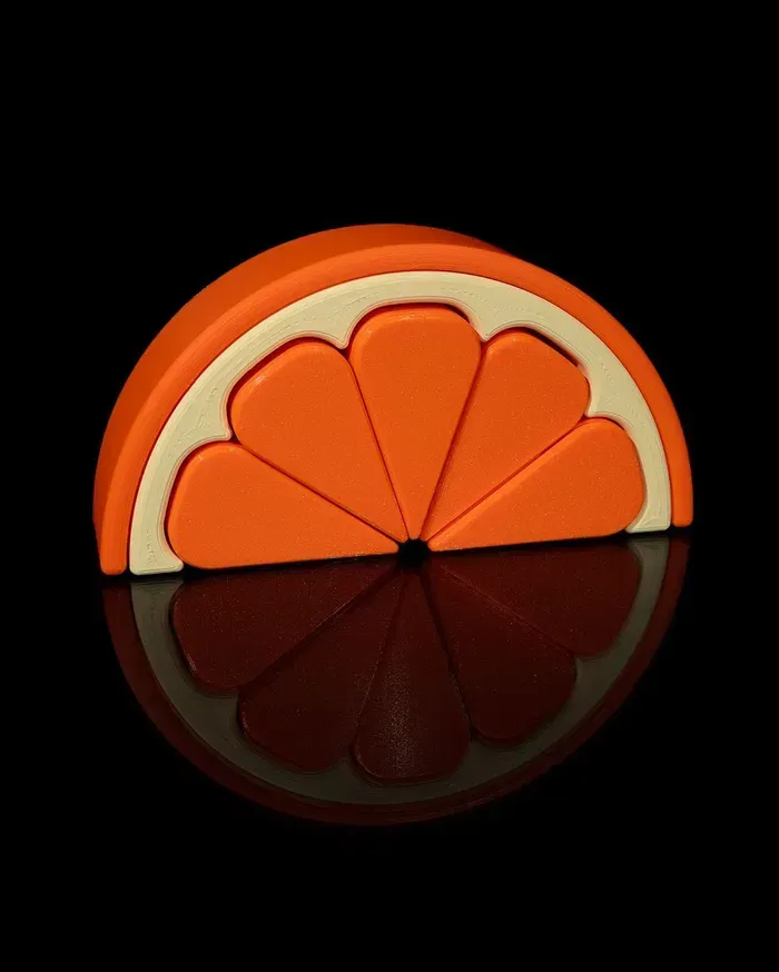 A slice of orange is sitting on a black surface