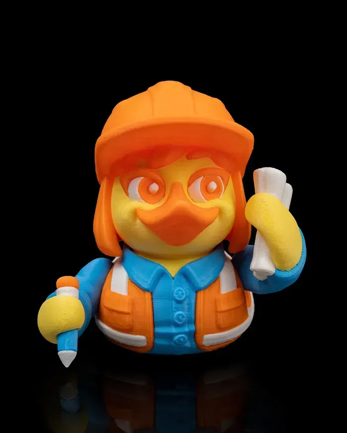 A rubber duck wearing a hard hat and vest is holding a pencil