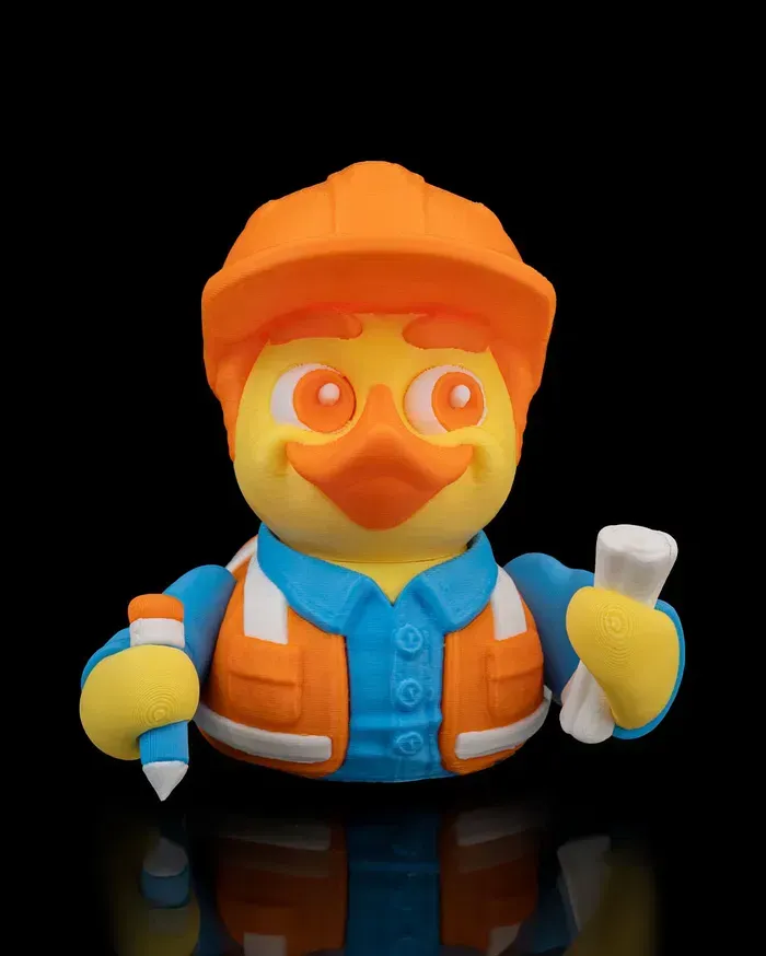A rubber duck wearing a hard hat and vest is holding a pencil