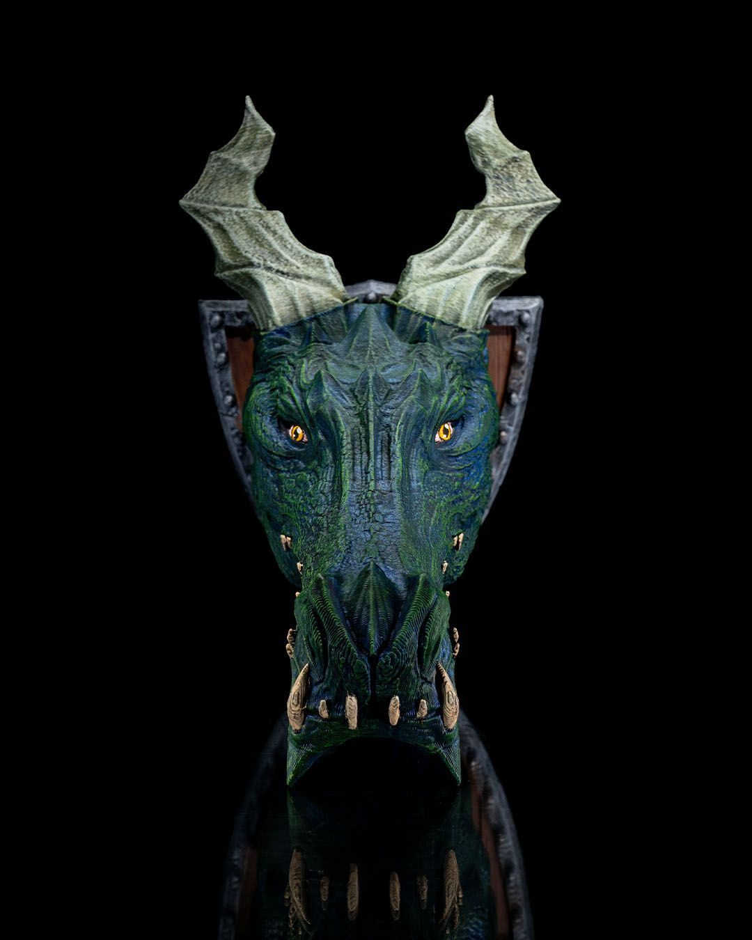 A close up of a dragon 's head with horns on a black background.