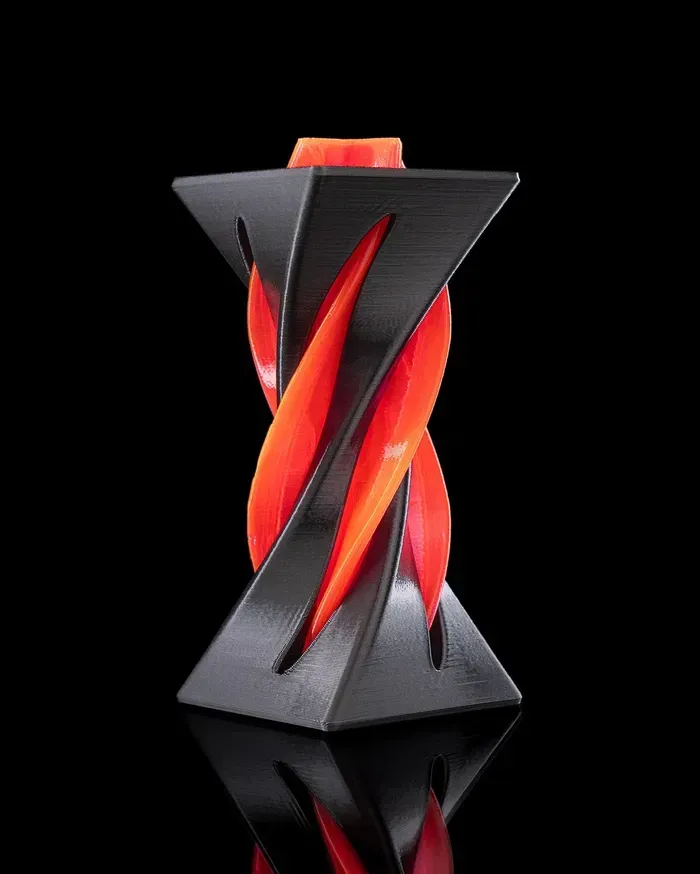A red and black object is sitting on a black surface.