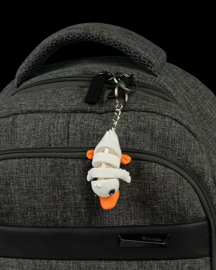 A close up of a backpack with a duck keychain attached to it.