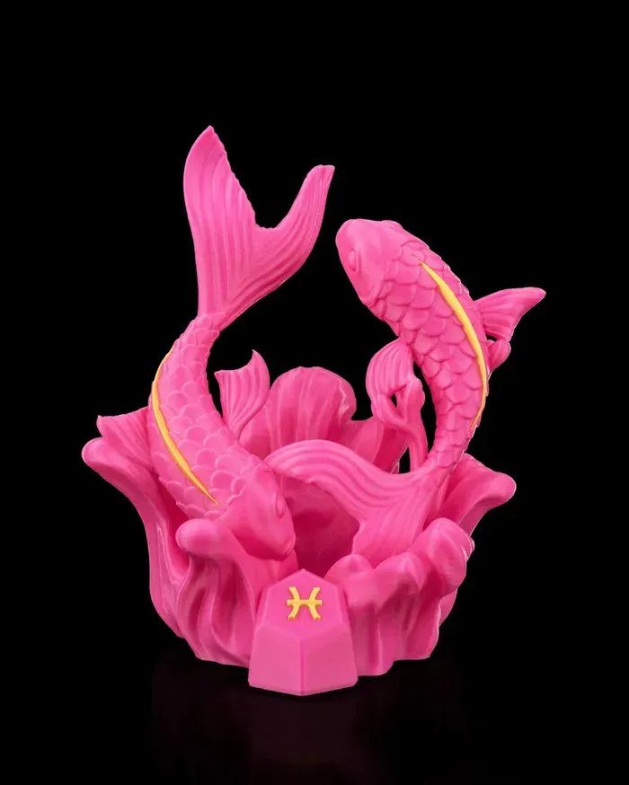 A pink statue of two fish with a yellow tail on a black background.
