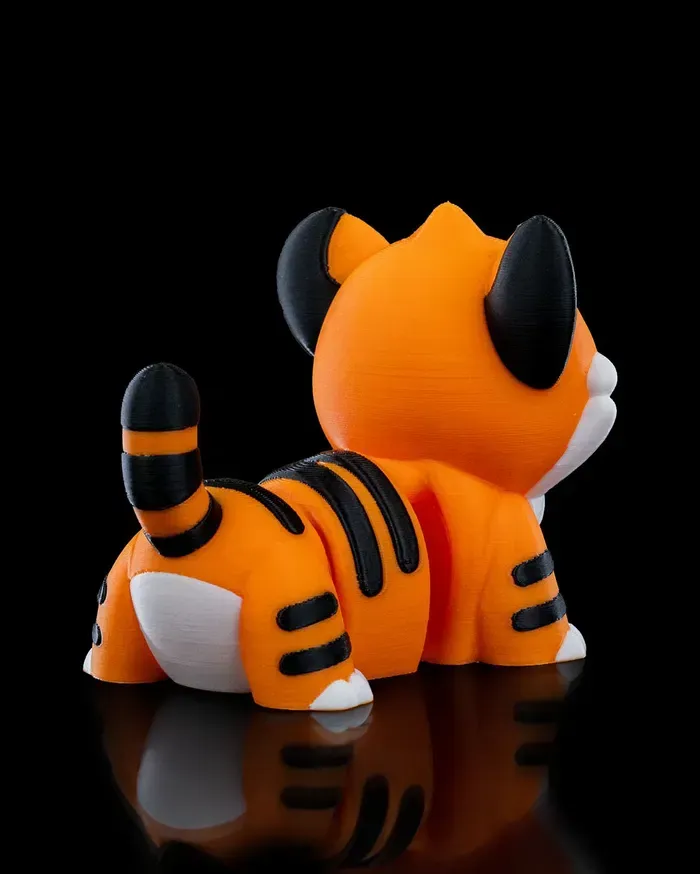 A small orange and white tiger figurine with a black background