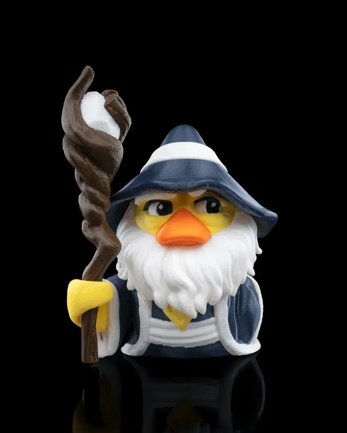 A rubber duck with a beard and hat is holding a cane.