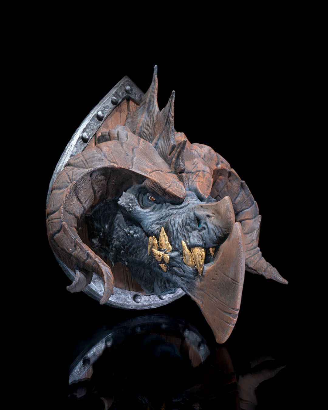 A close up of a statue of a dragon on a black surface.