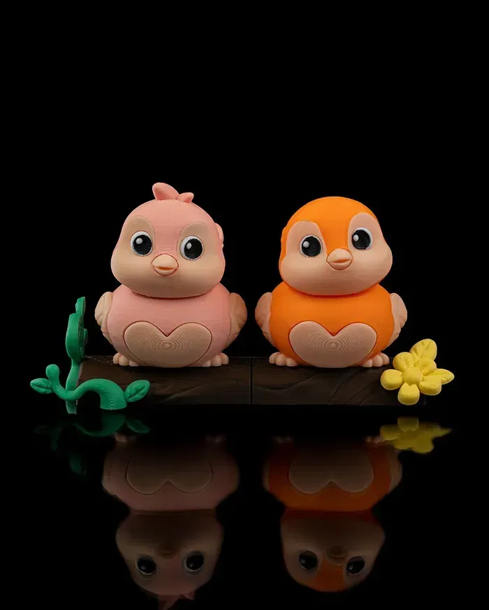 Two birds , one pink and one orange , are sitting on a tree branch.