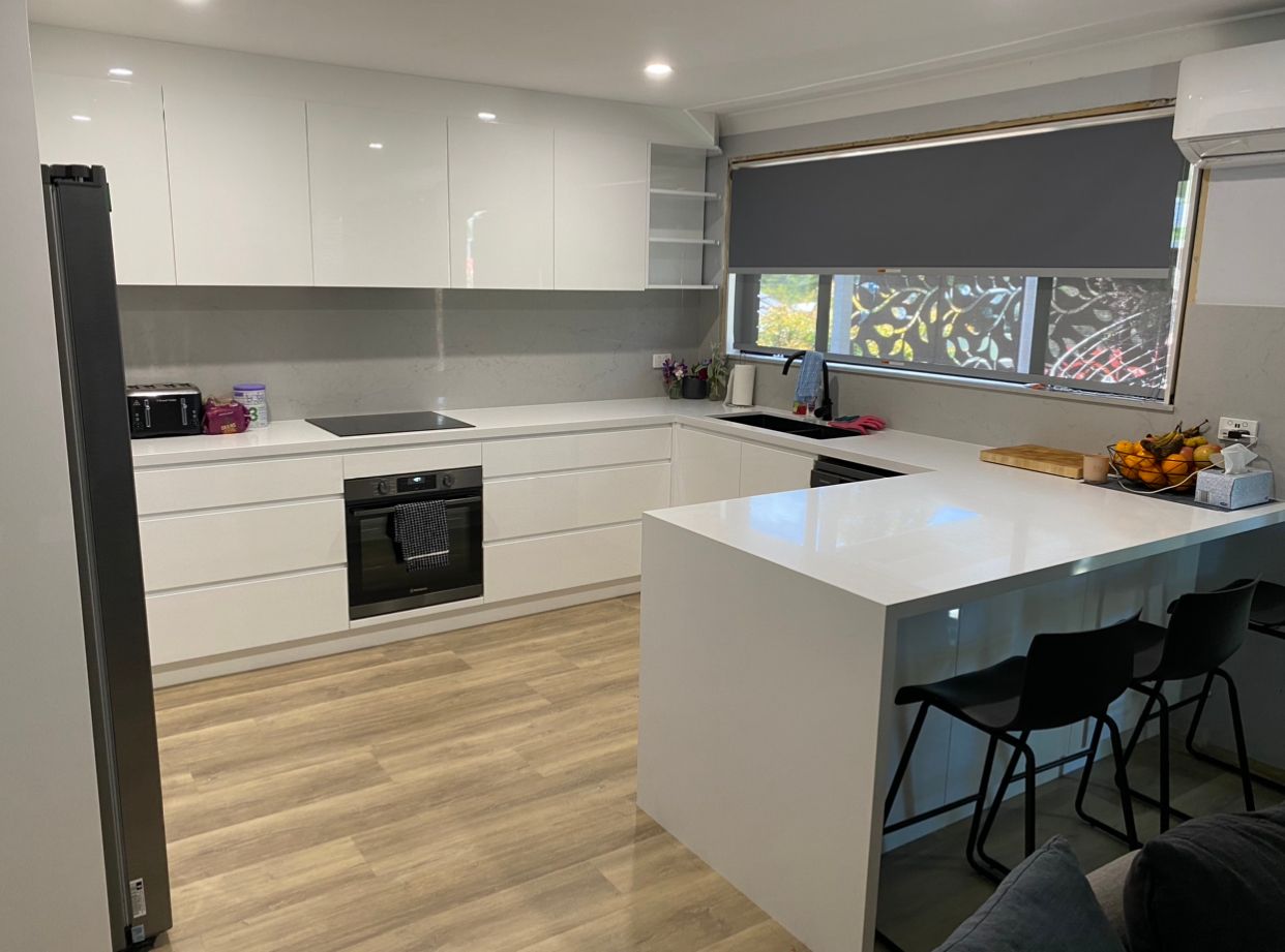 A Kitchen With White Cabinets, Stainless Steel Appliances, And A Large Island — United Kitchens and Joinery in Dapto, NSW