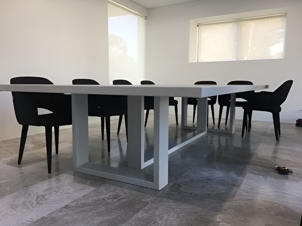 A White Table With Black Chairs In A Room — United Kitchens and Joinery in Oak Flats, NSW