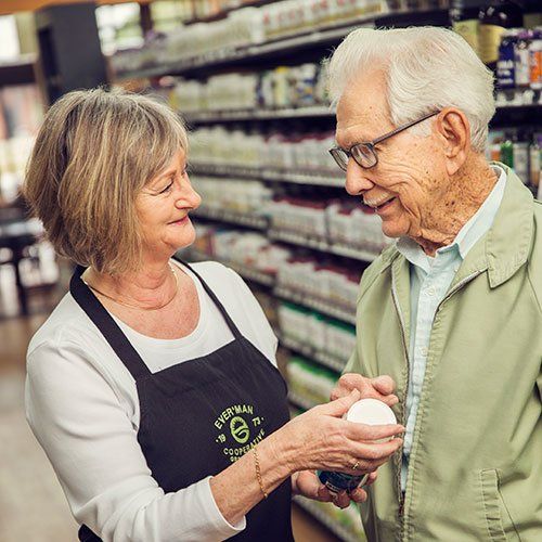 Ever'man Cooperative Grocery & Cafe Employee Assisting Elderly Shopper