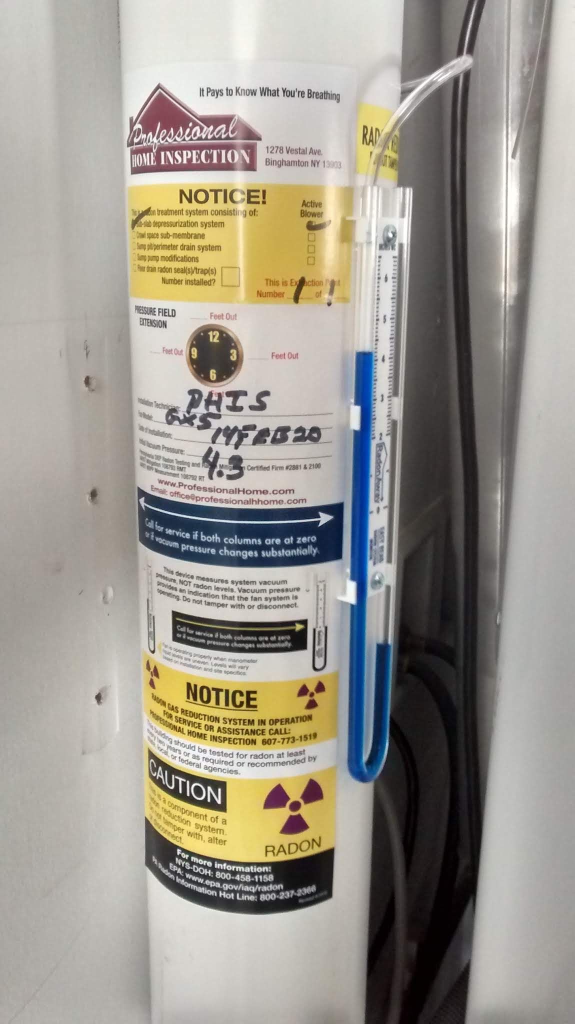 Utility pole with multiple yellow warning notices and a blue-and-white placard attached to the side.