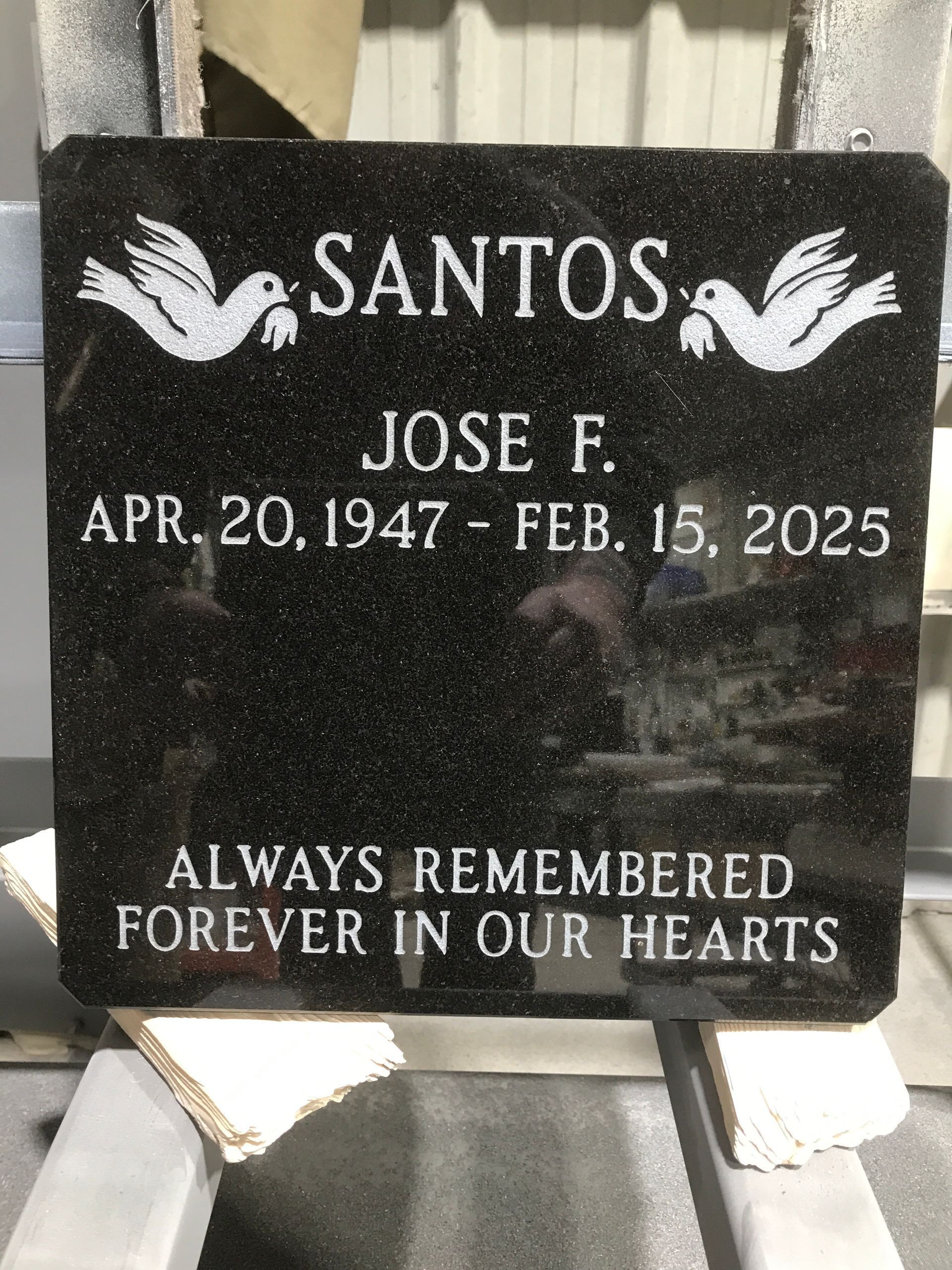 Black granite memorial headstone for Santos Jose F., with birth and death dates and “Always remembered forever in our hearts.”