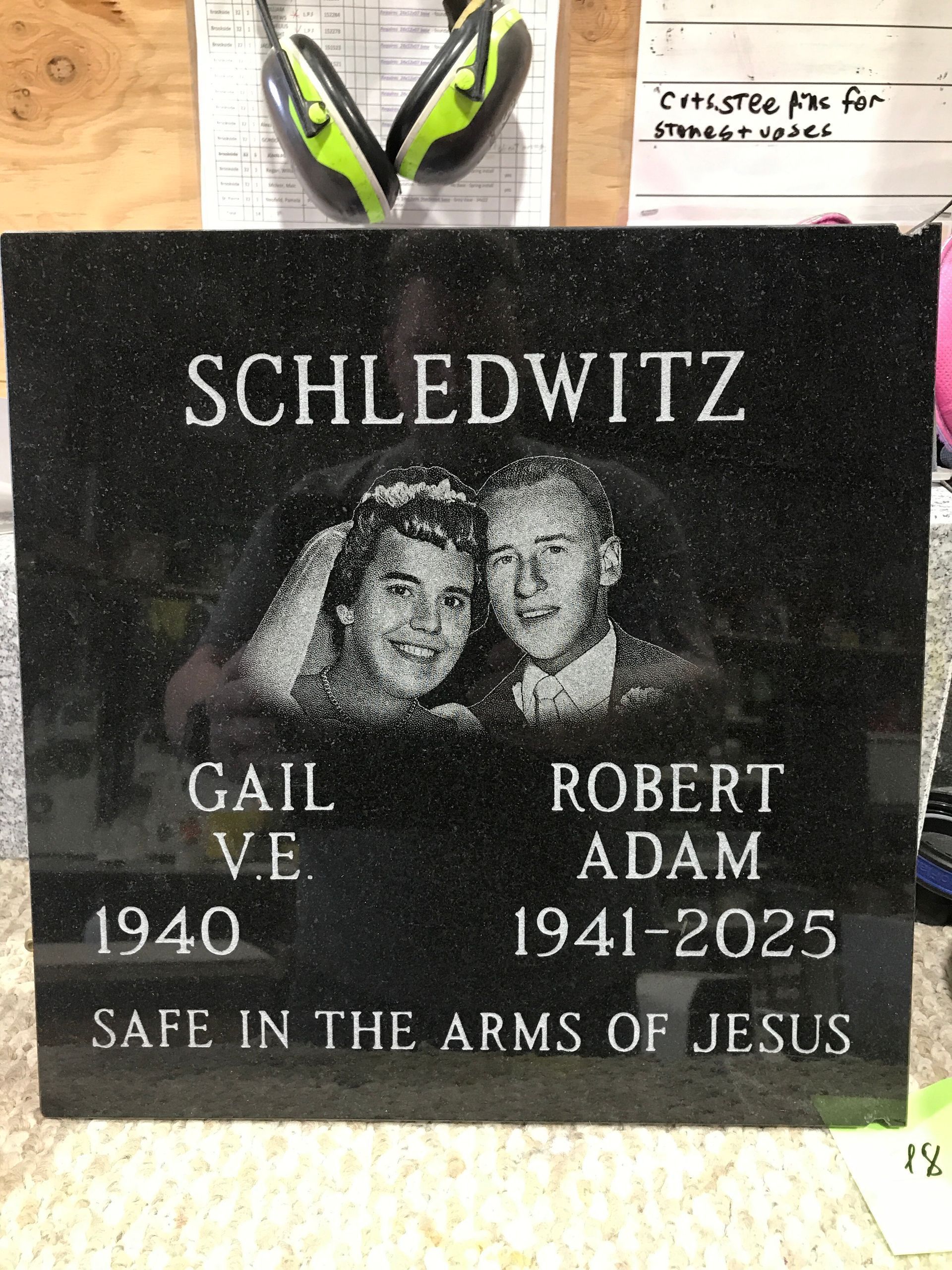 Memorial plaque reading “Schledwitz” with a black-and-white portrait and names Gail V. and Robert Adam, 1940–2025.