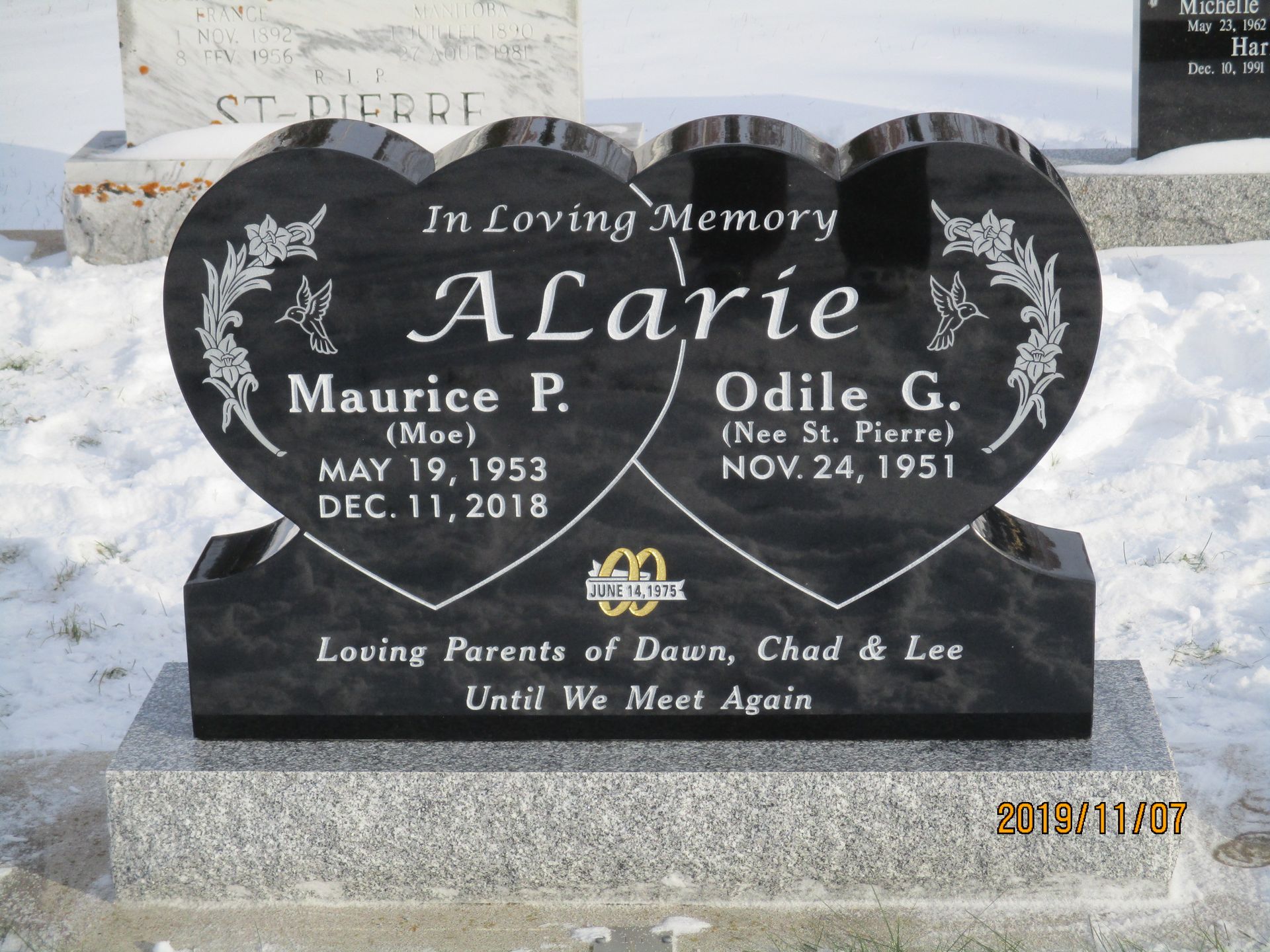 Black heart-shaped memorial headstone for Jacie, Maurice P., and Odile G. with engraved flowers and names