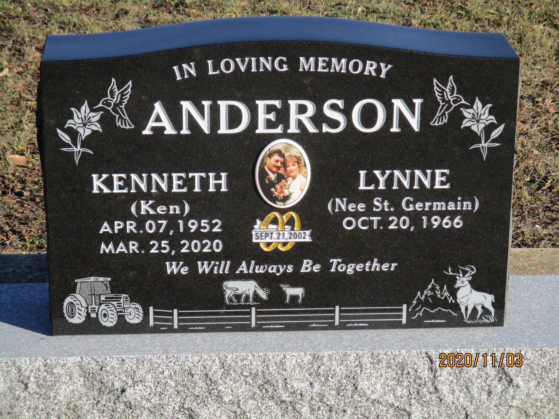 Black memorial gravestone with Anderson name, butterfly engravings, and a small photo oval.