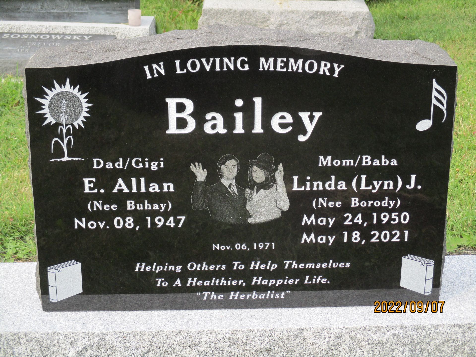Black gravestone memorial for Bailey with engraved handprints and the names E. Allan and Linda J.