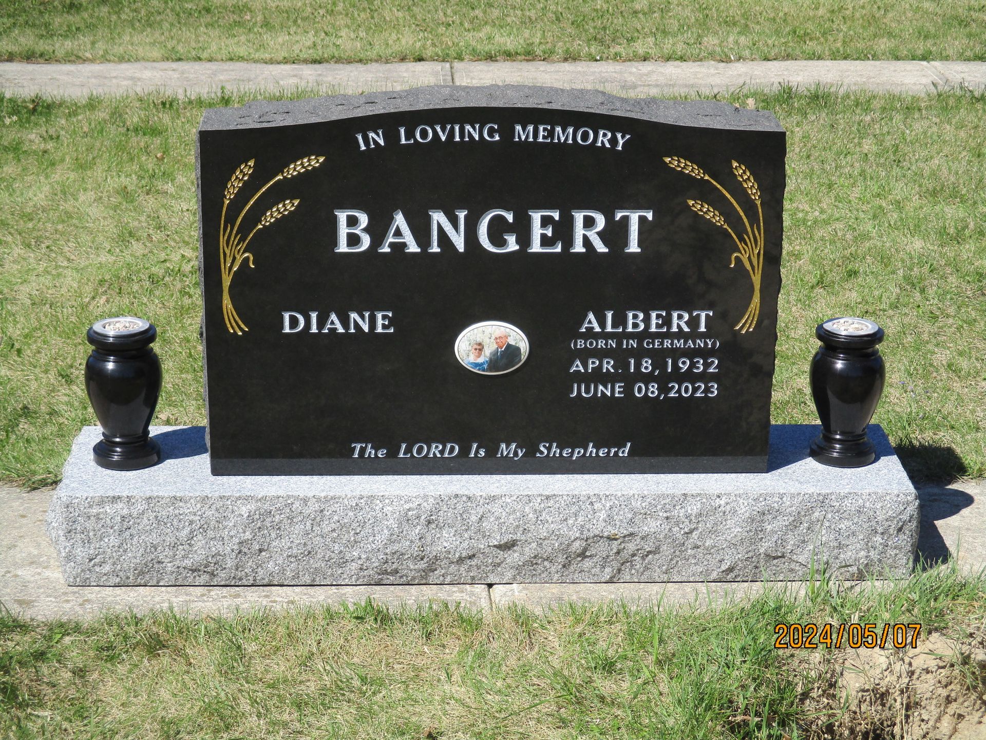 Black memorial gravestone for Diane and Albert Bangert on a gray base, set on grass.