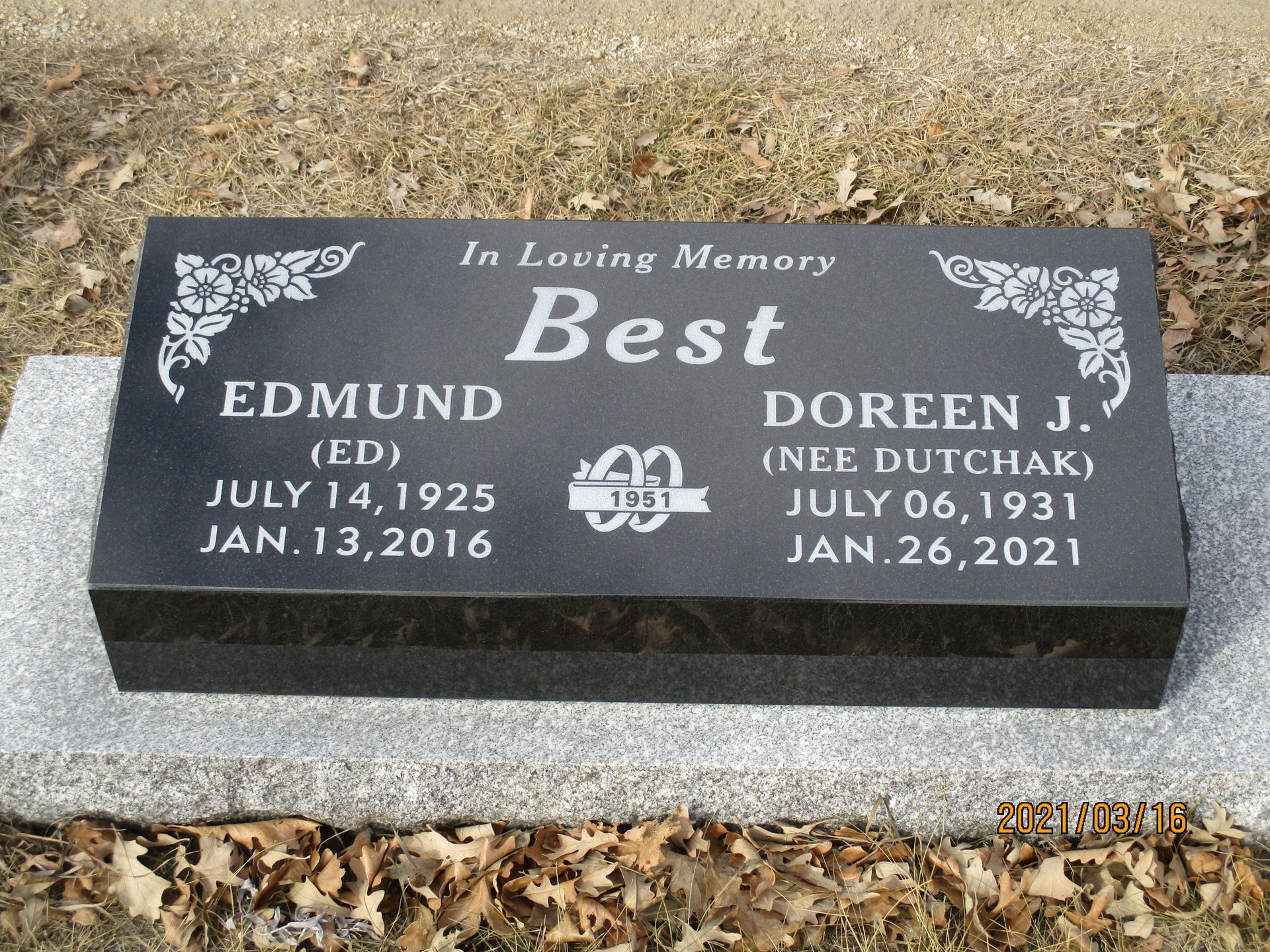 Black gravestone memorial for Edmund and Doreen J. Best on a gravelly cemetery plot.