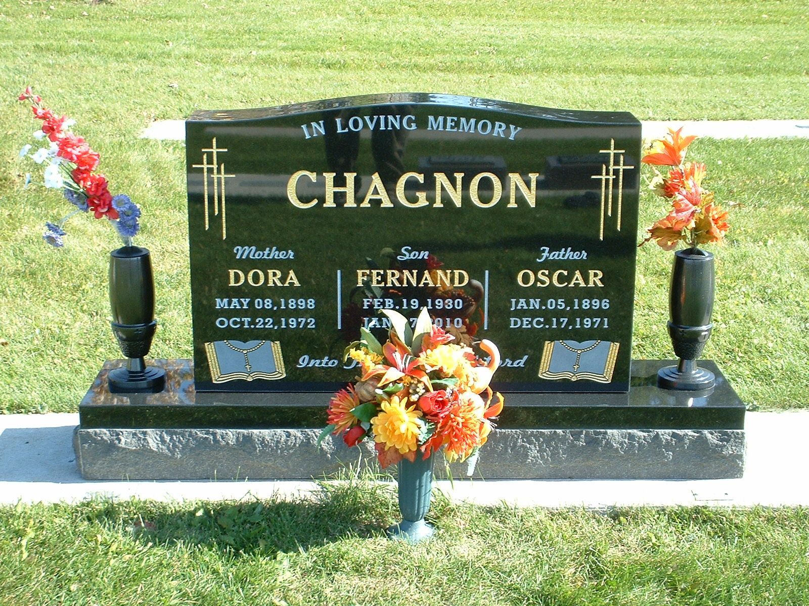 Memorial gravestone for the Chagnon family with flowers on a grassy lawn
