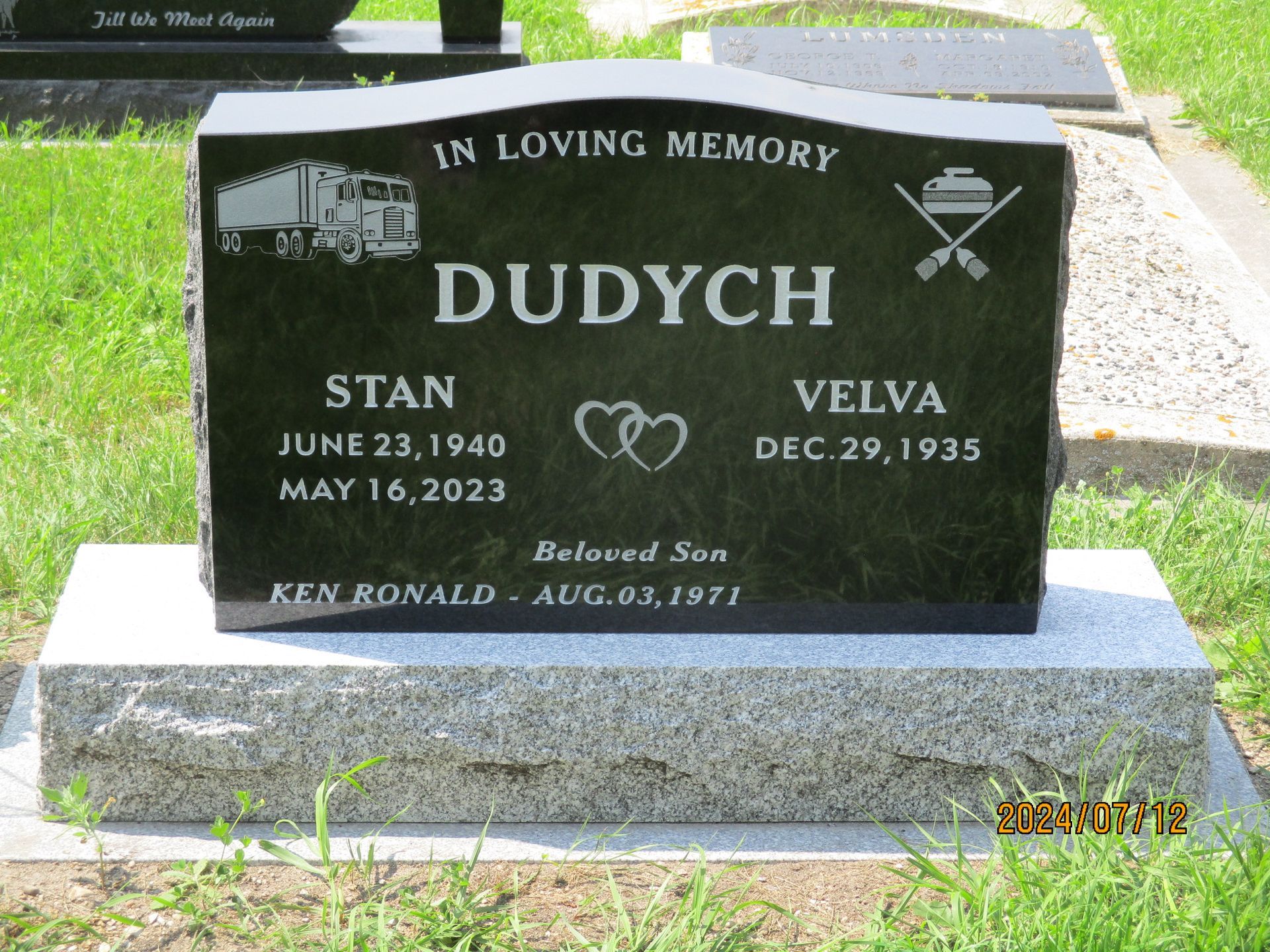 Black granite memorial headstone reading “In Loving Memory DUDYCH,” with names Stan and Velva.