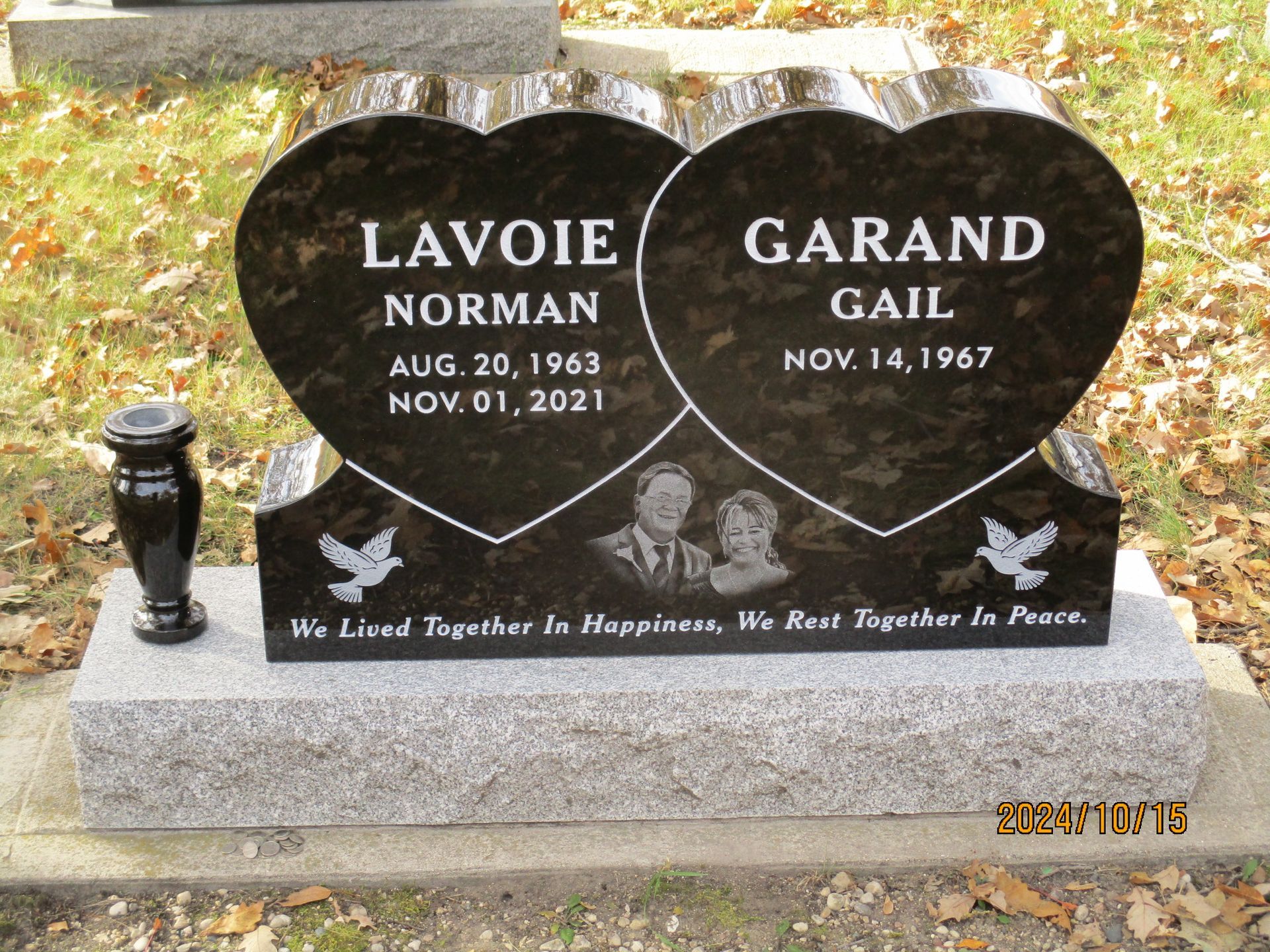 Black granite double headstone with the names Lavoie Norman and Garand Gail, decorated with white doves.