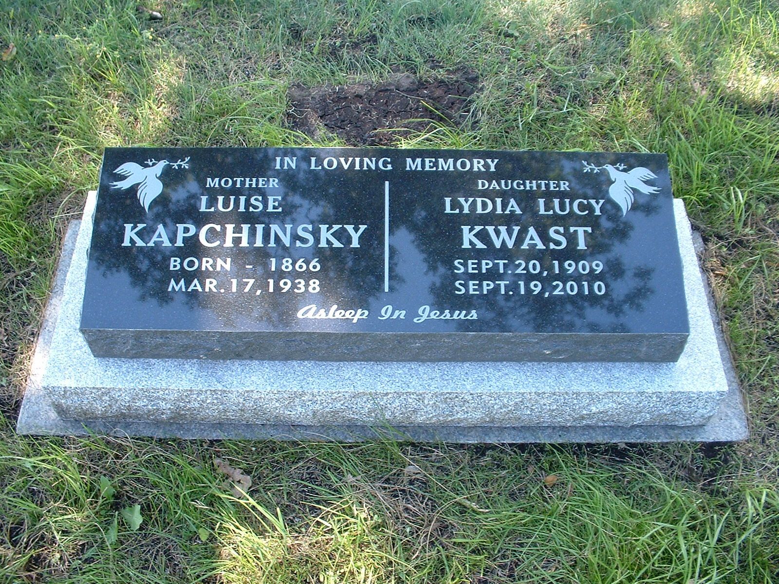 Memorial gravestone for Louise Kapchinsky and Lydia Lucy Kwasi with engraved names and dates