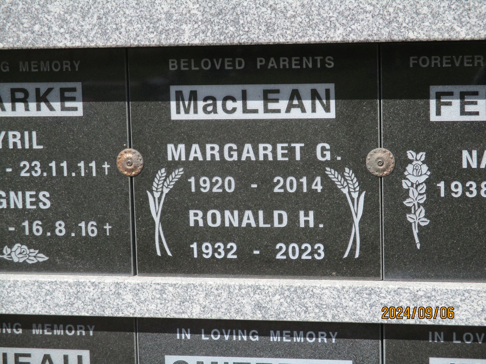 Black memorial wall plaques with white engraved names and dates, including MacLean, Margaret G., and Ronald H.
