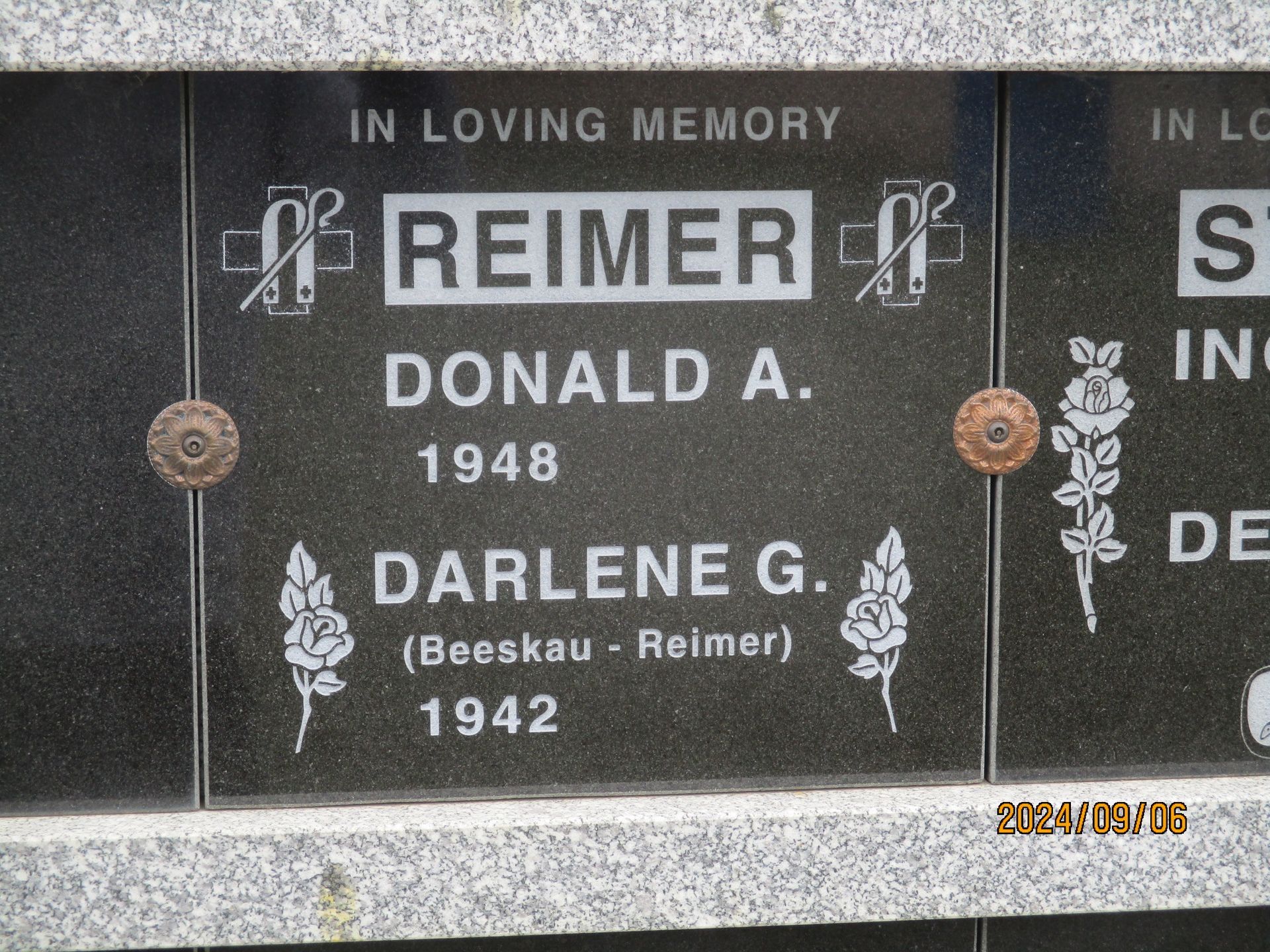 Black gravestone plaque with “Reimer,” Donald A. (1948) and Darlene G. (1942) in white lettering