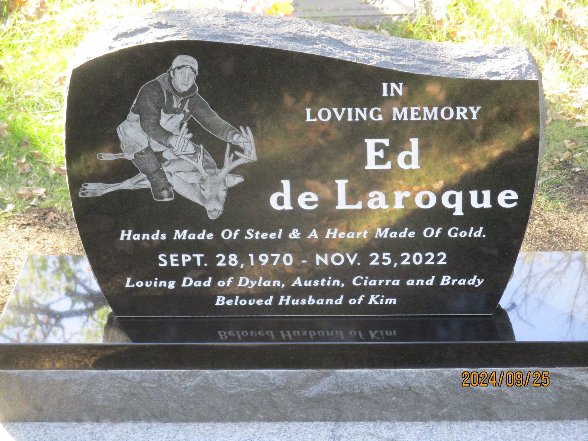 Black granite memorial plaque with engraved photo and white text for Ed de Laroque, Oct 28, 1970–Nov 25, 2022