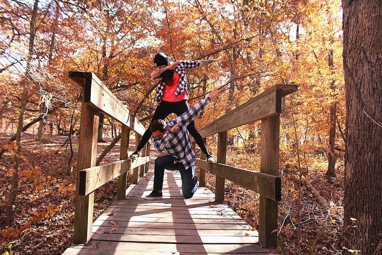 Dabbing to a wedding proposal on a wooden bridge.