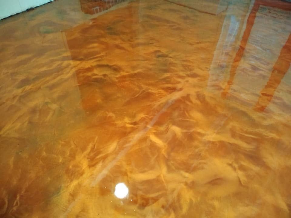 Metallic orange epoxy floor with swirls and reflections.