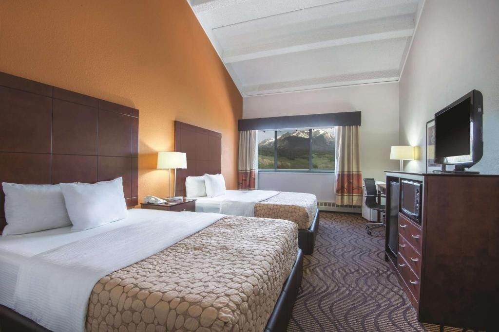 A hotel room with two beds and a television