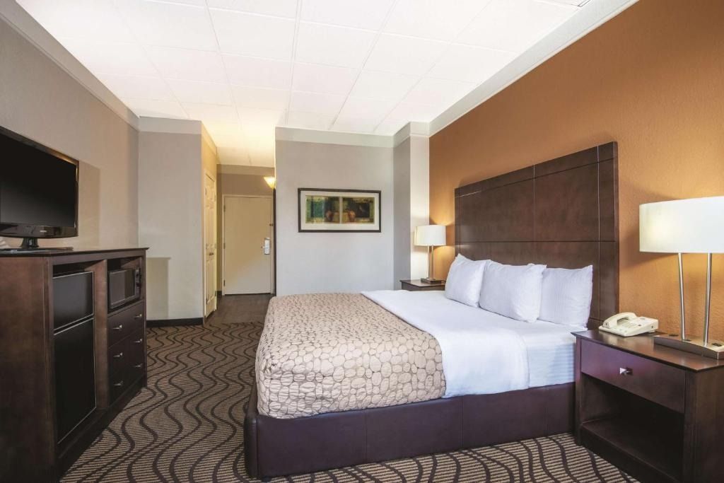 A hotel room with a king size bed and a flat screen tv.