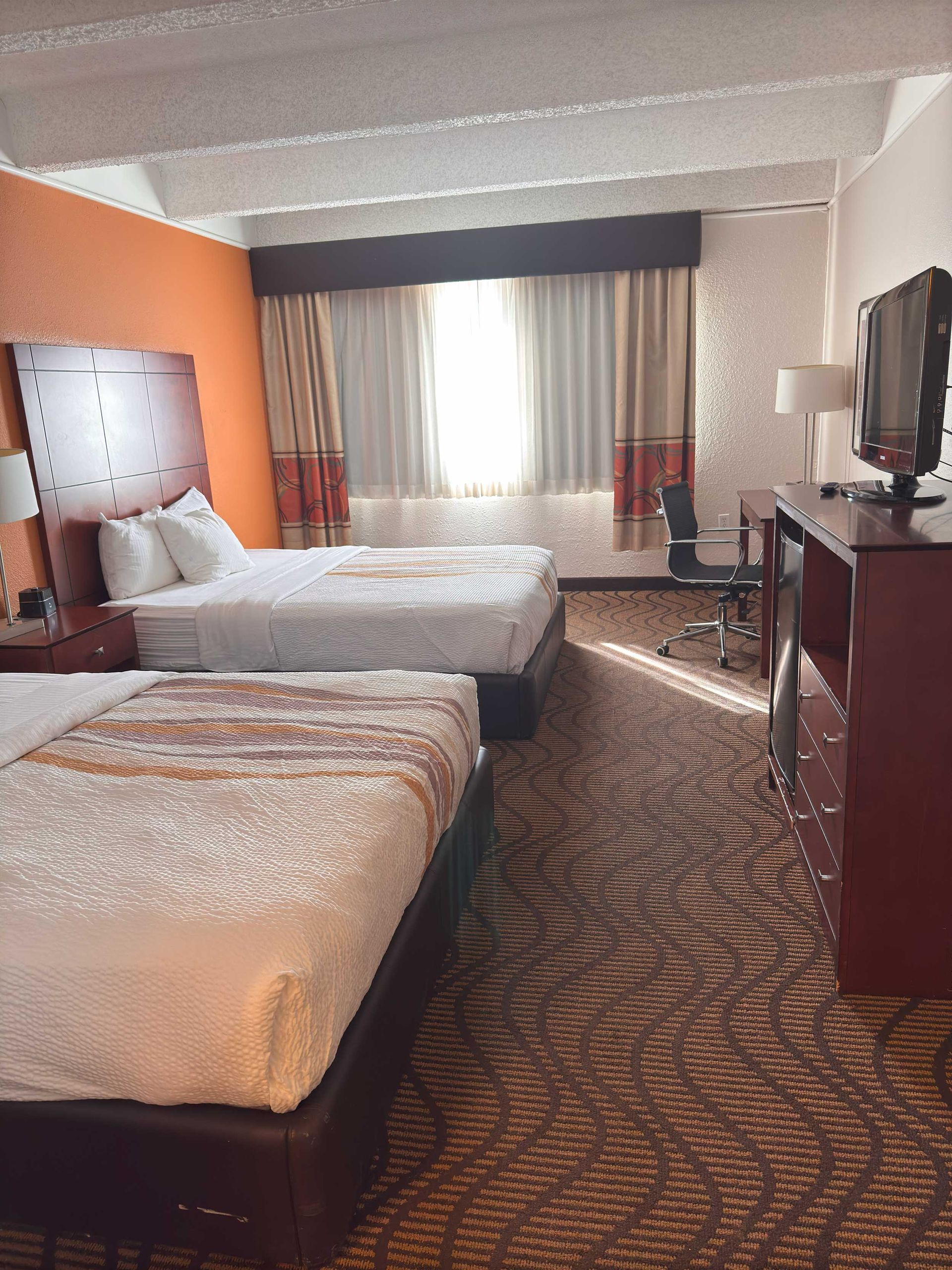 A hotel room with two beds and a television