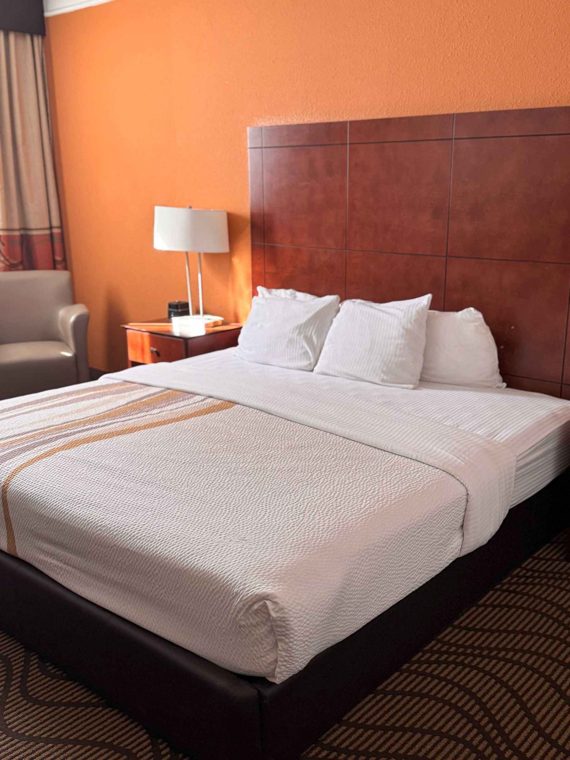 A hotel room with a king size bed , television , nightstand , desk and chair.