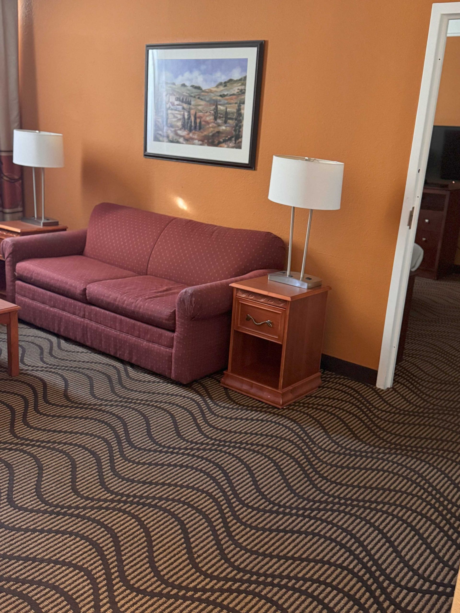 A living room with a red couch and two lamps