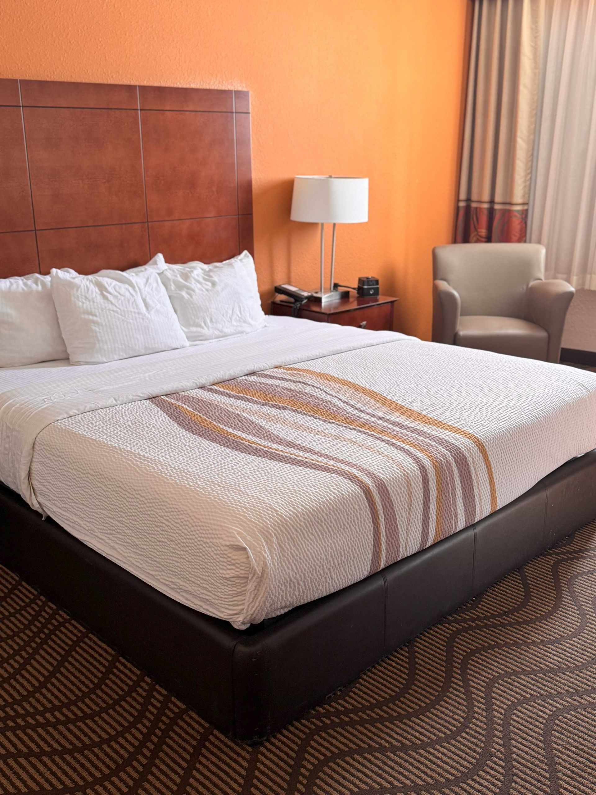 A hotel room with a king size bed and a flat screen tv.