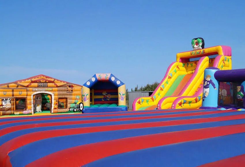 A Bunch of Bouncy Houses Are Lined Up in a Field — Fun Time Amusements in Mackay, QLD