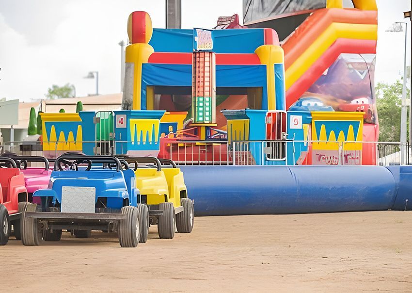 A Bunch of Small Cars Are Parked in Front of a Bouncy House — Fun Time Amusements in Gracemere, QLD
