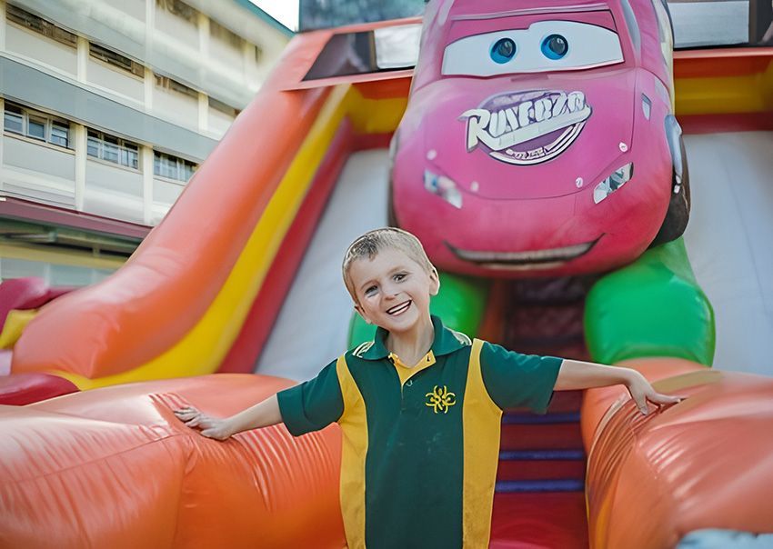 A Young Boy is Standing in Front of an Inflatable Cars Slide — Fun Time Amusements in Gracemere, QLD